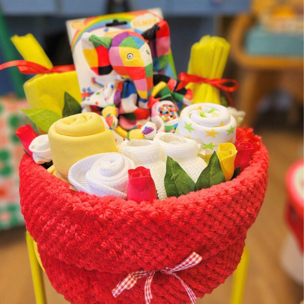 Bright nappy cake. Created using nappies and a soft baby blanket (and filled with lots of goodies), the gorgeous cake is then hand-wrapped in cello